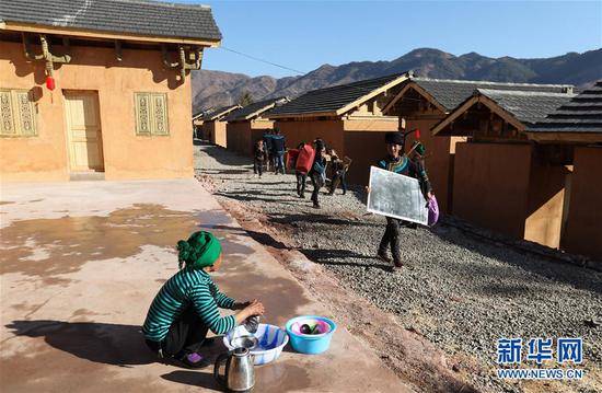 在昭觉县三河村易地扶贫安置点，马海日聪（右一）喜搬新居（2月11日摄）。2月11日，三河村首批29户、168人告别居住多年的土坯房，搬入易地扶贫安置点的新家。新华社记者江宏景摄