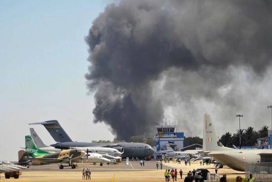 在耶拉汉卡空军基地举行的印度航空展23日突发大火，冒出滚滚浓烟。（法新社）