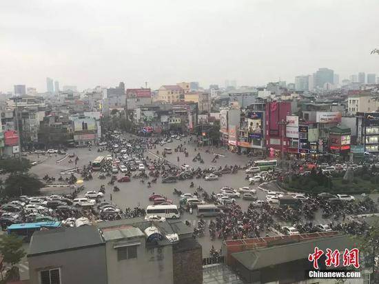 2月25日，越南首都河内，第二次朝美领导人会晤举行前，河内街头民众正常出行，摩托为当地主要出行方式之一。正值下班高峰期，大量摩托车在路口准备过路。中新网记者孟湘君摄