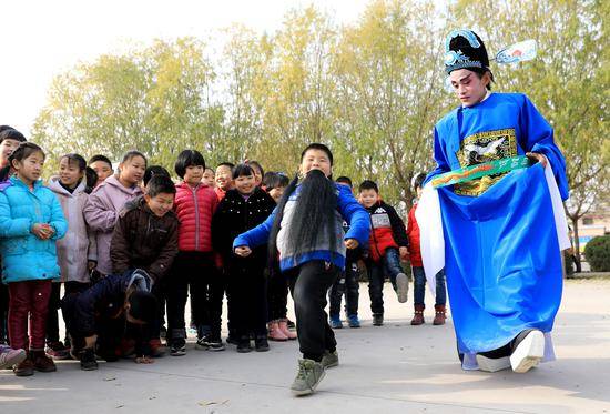 ↑在河北省晋州市李家庄小学，非遗“李家庄咳嗨腔”表演队队员与小朋友互动（2018年11月28日摄）。新华社记者赵丹惠摄