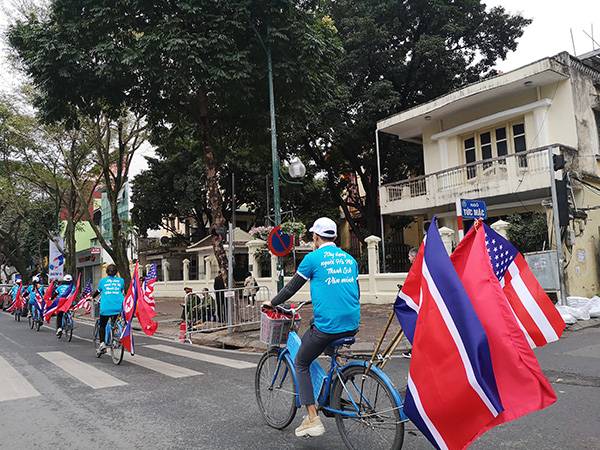 身穿蓝色制服，头戴白色帽子的大学生志愿者们，正骑着悬挂着美越朝三国国旗的自行车在河内街头环游，为即将到来的“金特会”造势。李禾悦供图
