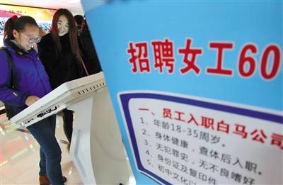 2017年3月3日，山东烟台，女性求职者在信息屏上查找招聘信息。资料图片/视觉中国
