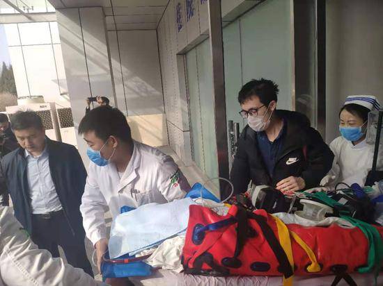 患者被送上救护车。摄影新京报记者戴轩