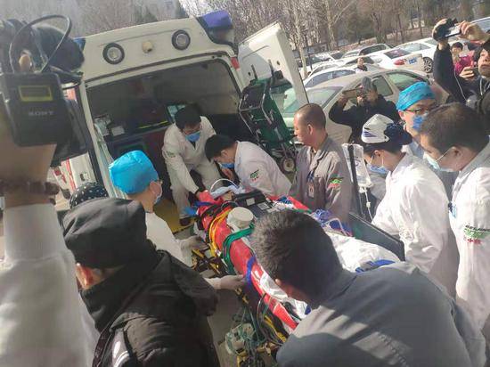患者被送上救护车。摄影新京报记者戴轩
