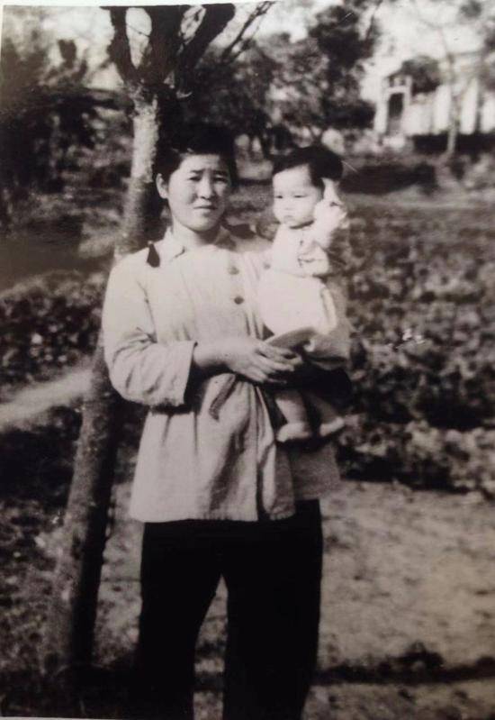 渡边在部队大院，怀里抱的小孩是40军军长温玉成的长女