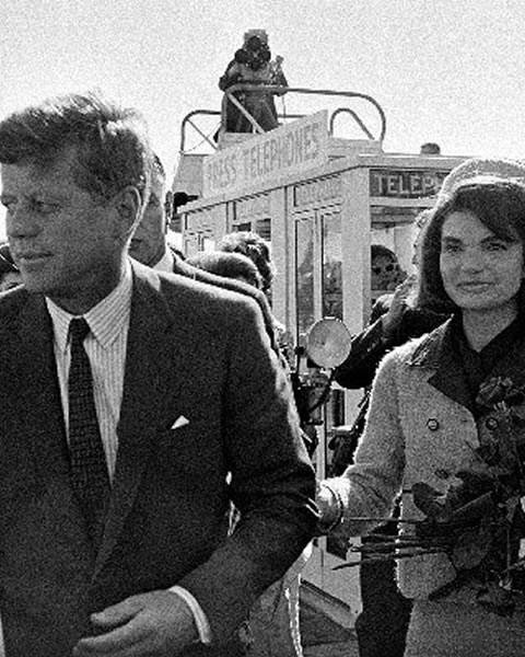 1963年11月22日，美国前总统肯尼迪左与夫人杰奎琳飞抵得州达拉斯，在机场接受献花。