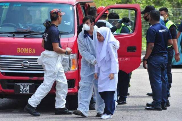 3月13日，在马来西亚南部柔佛州巴西古当地区，身体不适的学生被送往医院救治。新华社发