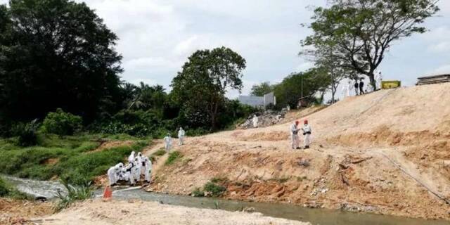 3月13日，在马来西亚南部柔佛州巴西古当地区，环境部门工作人员在河流处取样。新华社发