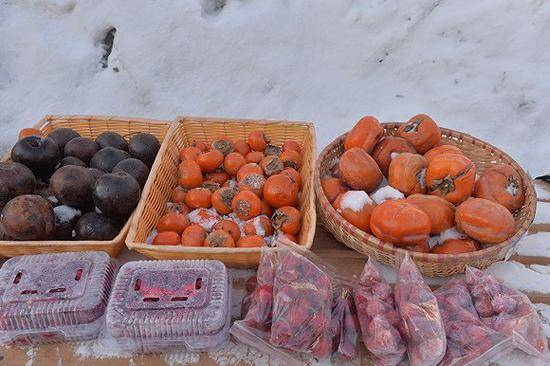 2019年1月4日，双峰林场中国雪乡风景区商贩卖的冻柿子和梨子。图片来自视觉中国