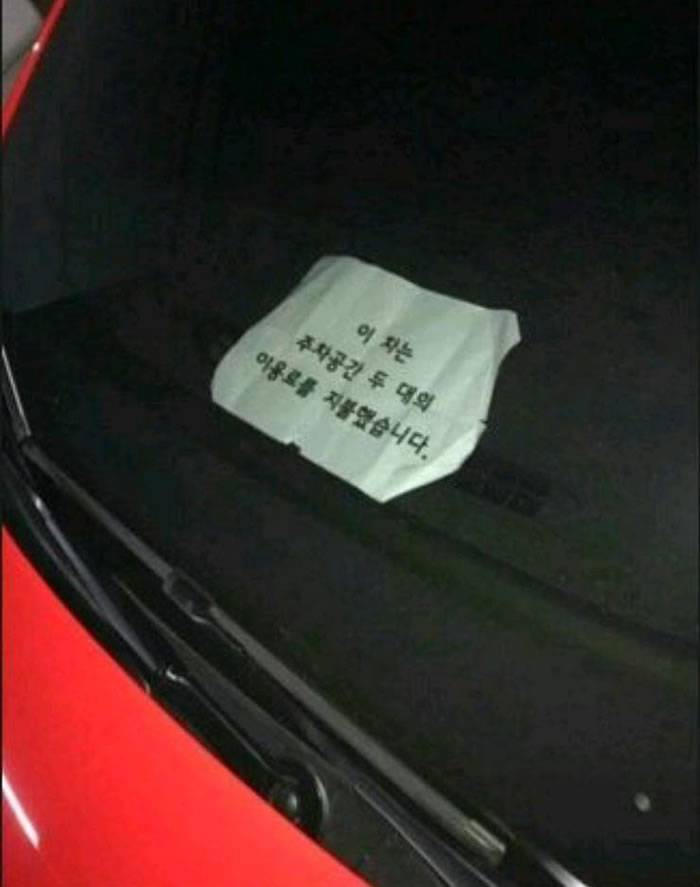 红色兰博基尼停在2格车位中间，靠近仔细一看车内纸条写着：这台车已经缴纳了2个车位的停车费用。