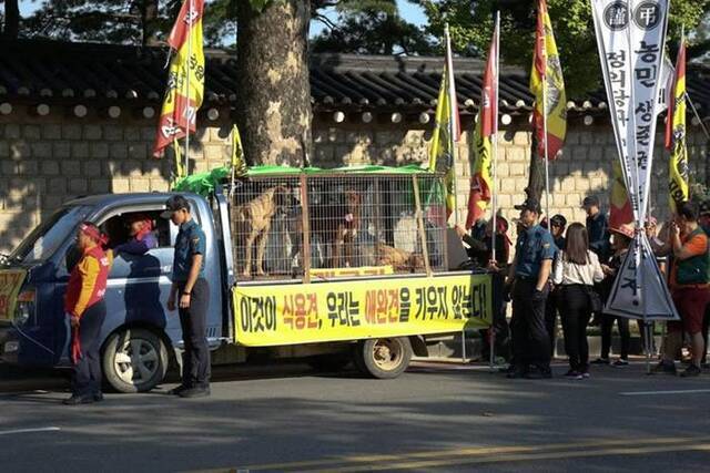 铁笼外贴上标语写道：“它们是人类的食物，不是宠物。”