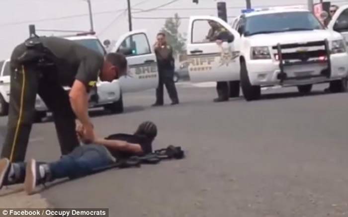 警员随即下车并掏出手枪瞄准黑人，到场支援的警员将黑人锁起。