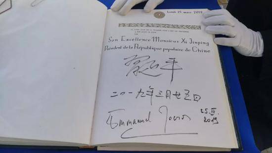 △习近平和马克龙在贵宾簿上签字。（央视记者李铮拍摄）