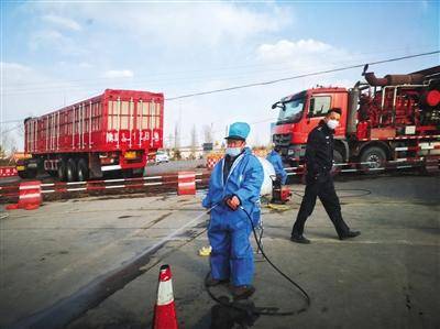 陕西省榆林市靖边县发生非洲猪瘟疫情后，3月9日，靖边张家畔一公路交叉口，工作人员在交警配合下，对过往车辆喷洒消毒液。图/视觉中国