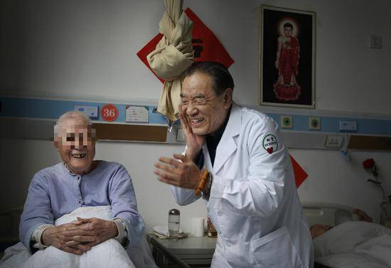 2019年3月14日，北京松堂医院，院长李伟正在逗坐在病床上的老人开心。新京报记者尹亚飞摄