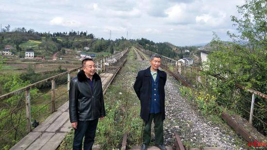 刘义建（左）和郑安明（右）站在已经废弃的蓝家河铁路桥上