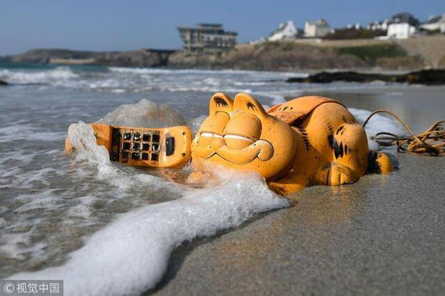 被冲到海边的“加菲猫电话”（图源：视觉中国）