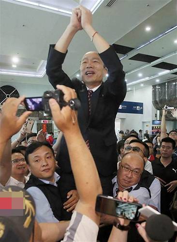 高雄市长韩国瑜28日结束出访抵达高雄小港机场，受到万名“韩粉”、民众热情接机，韩国瑜为向在场所有人挥手致意，身旁2名随扈把他高高举起。（图片来源：台湾“中时电子报”）