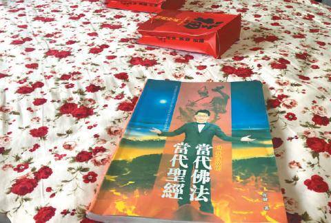 3月15日，陷入“五行币”传销的周英（化名）向记者出示了关于传销头目张健的书籍。新京报记者刘经宇摄