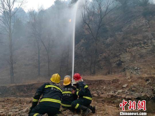 4月2日18时许，山西沁源山火威胁到赤石桥乡实会湾村民宅和蔬菜大棚安全，数百名救援人员在烟雾和沙尘弥漫的山沟内持续逆火冲锋，成功阻止了火势向实会湾村蔓延。图为消防员用水枪进攻山林明火。陆祁国摄