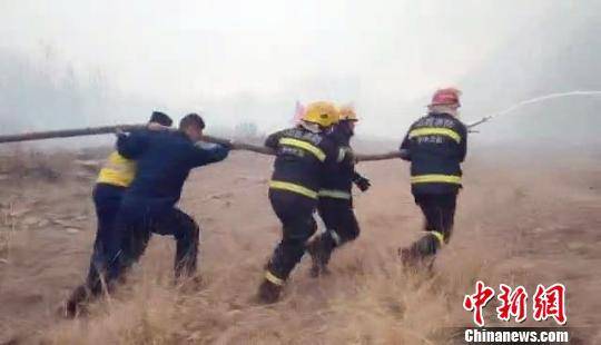 4月2日18时许，山西沁源山火威胁到赤石桥乡实会湾村民宅和蔬菜大棚安全，数百名救援人员在烟雾和沙尘弥漫的山沟内持续逆火冲锋，成功阻止了火势向实会湾村蔓延。图为消防员奋力向前推进水枪阵地。陆祁国摄