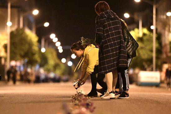 在车队到来之前，当地群众在街道中间摆上鲜花祭奠英雄。