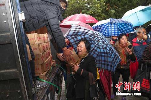 资料图：上海百名居民在雨中排成一条长龙，领取刚到货的秭归脐橙。拼多多供图