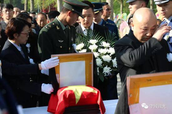 4月6日，成都市烈士陵园，战友和工作人员在摆放烈士李灵宏的遗像。中国青年报·中青在线记者王鑫昕/摄