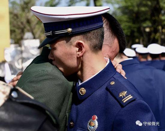  4月6日，成都市烈士陵园，一位武警战士和一位消防员拥抱在一起，为牺牲的战友哭泣。中国青年报·中青在线记者王鑫昕/摄