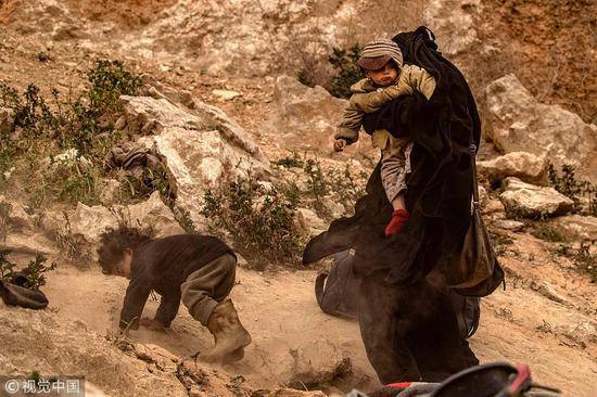 3月14日，叙利亚代尔祖尔省巴格霍兹村，IS恐怖分子及其家属步行投降图源：视觉中国
