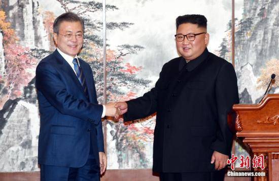 2018年9月19日，在朝鲜平壤，朝鲜国务委员会委员长金正恩（右）与韩国总统文在寅在举行共同记者会后握手。正在平壤访问的文在寅19日上午在百花园迎宾馆与金正恩举行第二轮会谈。会谈结束后，双方签署《9月平壤共同宣言》，就早日推动半岛无核化进程、加强南北交流与合作达成一致。中新社发平壤联合采访团供图