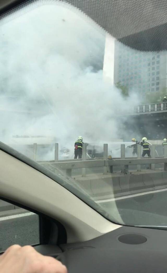 今日中午，北京市朝阳门桥下一小轿车起火，目前明火已被扑灭。受访者供图