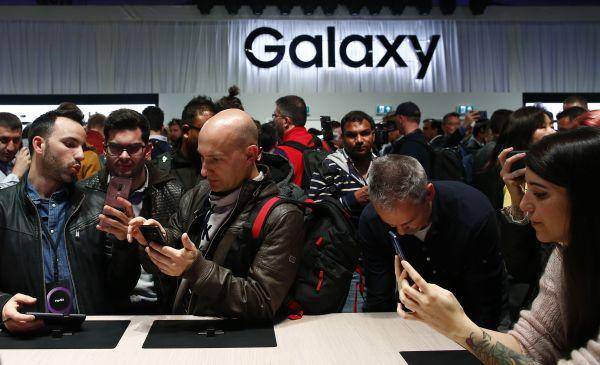 2月25日，在西班牙巴塞罗那，人们体验新款三星盖乐世S9手机。（新华社）