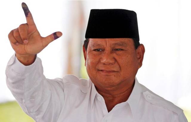 图说印尼总统候选人普博拉博沃在投票站投票后展示手指的墨迹来源：路透社