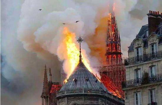 （图：法国巴黎圣母院遭遇火灾，塔尖坍塌。）