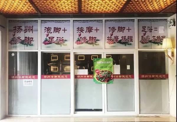 近日，岳阳市经开区，发生命案的修脚店大门紧闭，封条被海报遮了起来。受访者供图