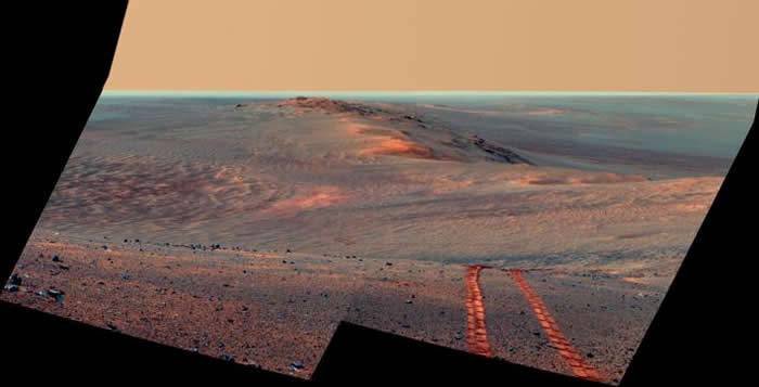 2014年8月15日，机遇号在火星之旅的第3754个火星日，回望奋进陨石坑西侧的环形山，拍下疲惫的车轮碾压后的胎痕，纪念这趟前所未有的火星探测之旅。 PHOTO