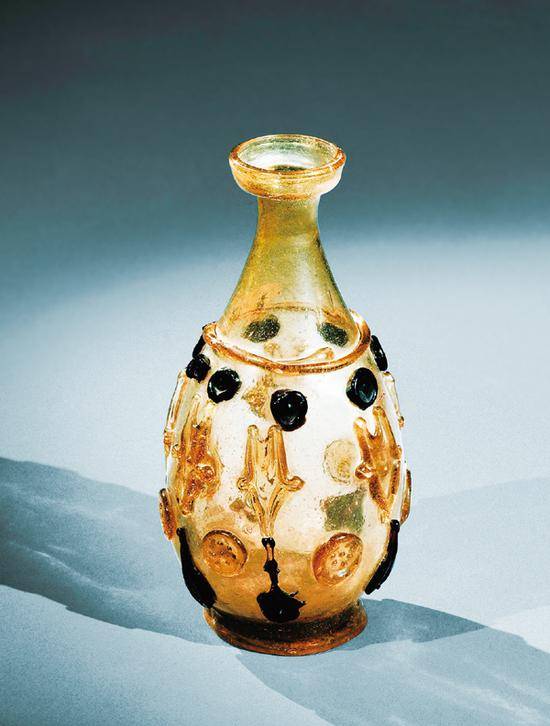 1987年，在中国陕西的法门寺，地宫中出土了20件美轮美奂的琉璃器，这是唐代传入中国的东罗马和伊斯兰的琉璃器。图为法门寺地宫中出土的盘口细颈贴塑淡黄色琉璃瓶。法门寺博物馆供图