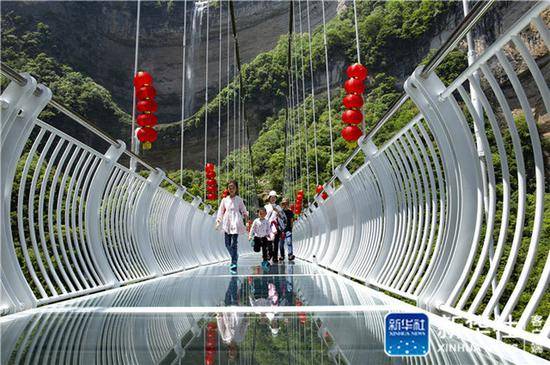 ↑5月2日，游人在湖北省宜昌市秭归县三峡竹海生态景区玻璃天桥上游玩。新华社发（王罡摄）
