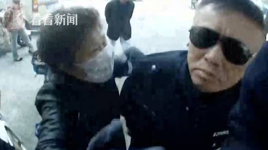 面对执勤交警，吴大妈情绪失控，五次动手，执勤交警佩戴的执法记录仪被打掉。