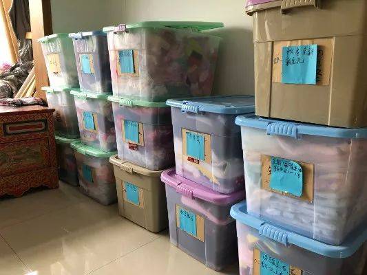 护生小居内，好心人捐赠的新生儿衣物分门别类放在收纳箱中。新京报记者杜雯雯摄