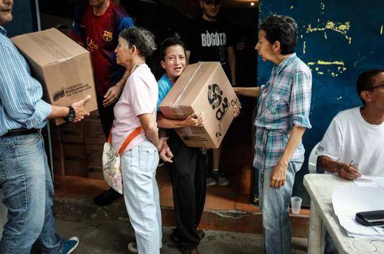 加拉加斯市中心一个社区内居民领取食品箱。新华社发