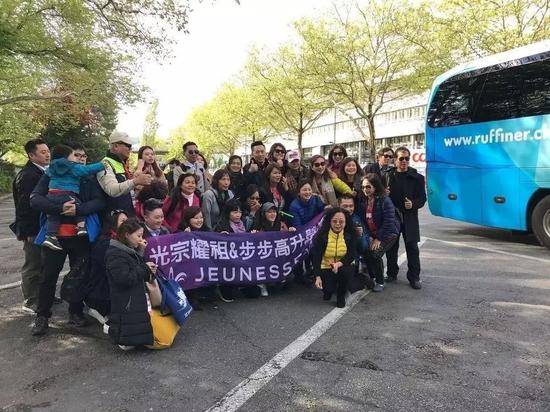 ▲婕斯公司组织的中国经销商旅游团，拿着“光宗耀祖&ampamp；步步高升”的横幅合影。图片来源/ 20 Minuten