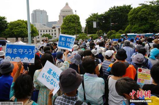 资料图：当地时间2015年5月24日，日本东京，示威者包围日本国会大厦，抗议美军在冲绳建设新的军事基地。