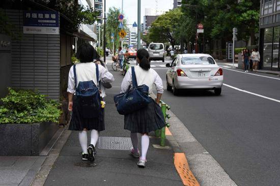 资料图：日本街头的学生（法新社）