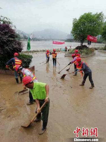  5月18日，洪水过后，当地市政部门组织清理江滨公园淤泥。