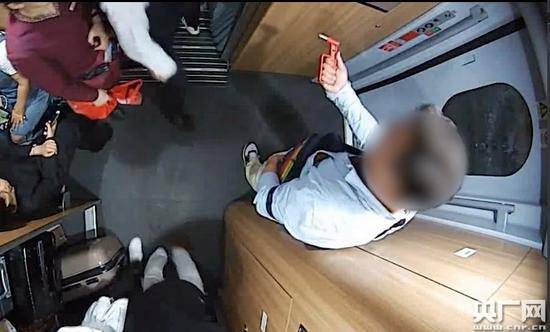男子取下车厢里的紧急破窗锤。（北京铁路警方供图）