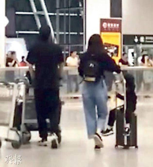张丹峰（左）与洪欣前天（5月17日）在内地机场各自推行李，偷拍照片的网民说两人全程零交流。