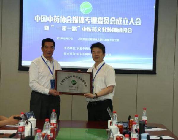 图为中国中药协会刘张林副会长（左）为媒体专业委员会授牌