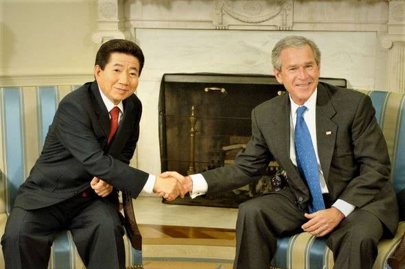 2005年6月10日，卢武铉总统和小布什总统在美国华盛顿白宫举行韩美首脑会谈后握手拍照留念。图丨韩民族日报